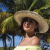 Modelo posando un sombrero para dama en la playa